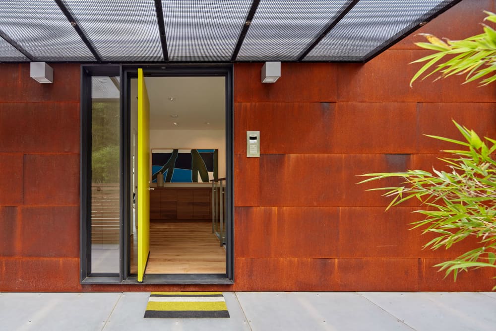 Bright doors makes for an eye catchy accent in a red rust metal siding