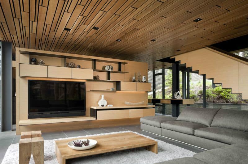 Creative wooden ceiling is echoed by a staircase and an entertainment center