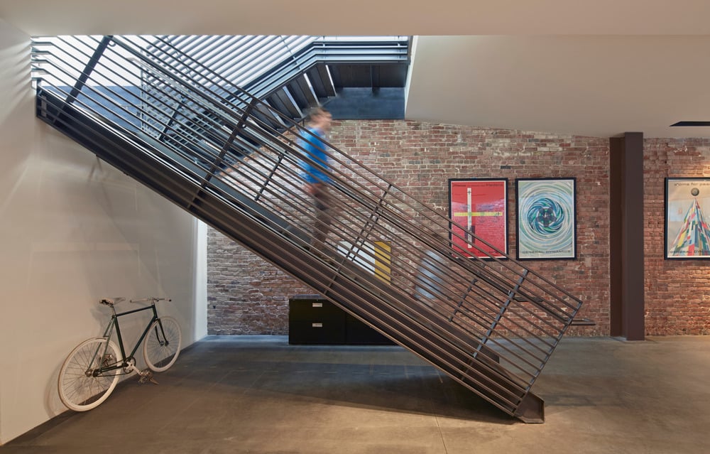 Exposed brick contrasts nicely with the metallic staircase and bright artworks