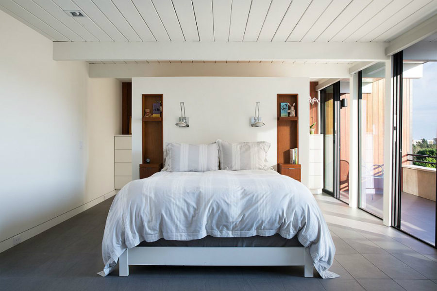 Glazed balcony walls illuminate bedroom with natural light