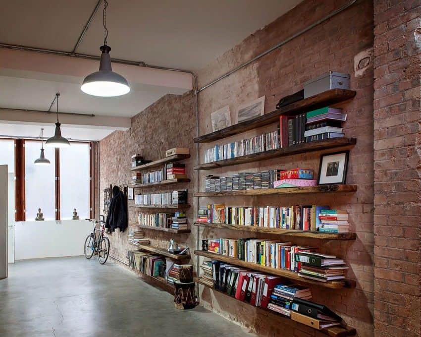Library shelving on brick walls - Shoreditch Warehouse Conversion