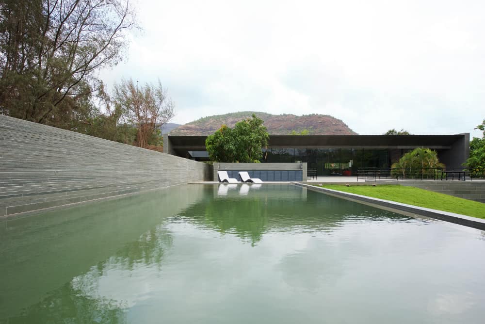 Natural swimming pool sits next to a green hill
