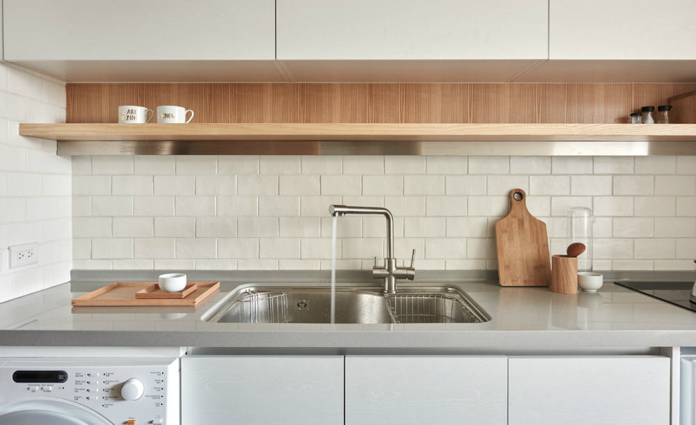 Simple tiles wrap around the kitchen walls to make cleaning easier
