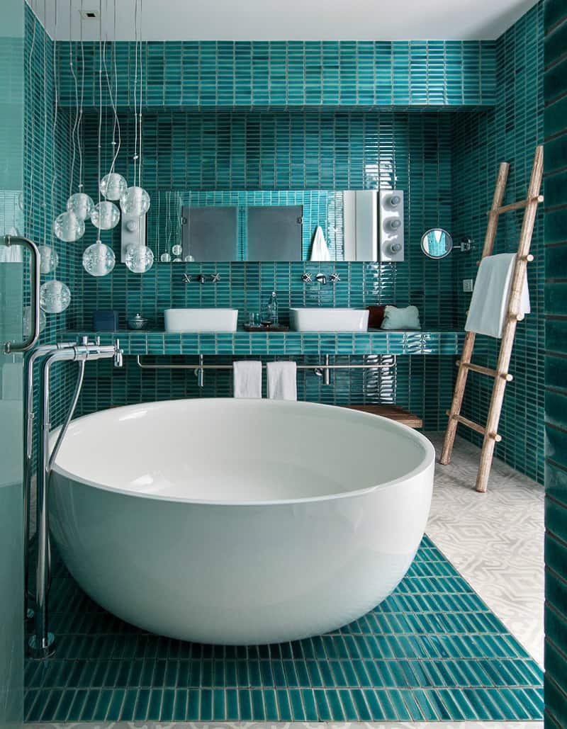 Teal bathroom with a small freestanding tub