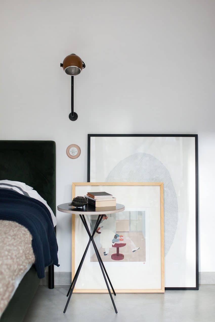 A couple of framed art prints lean against the wall behind a nighstand