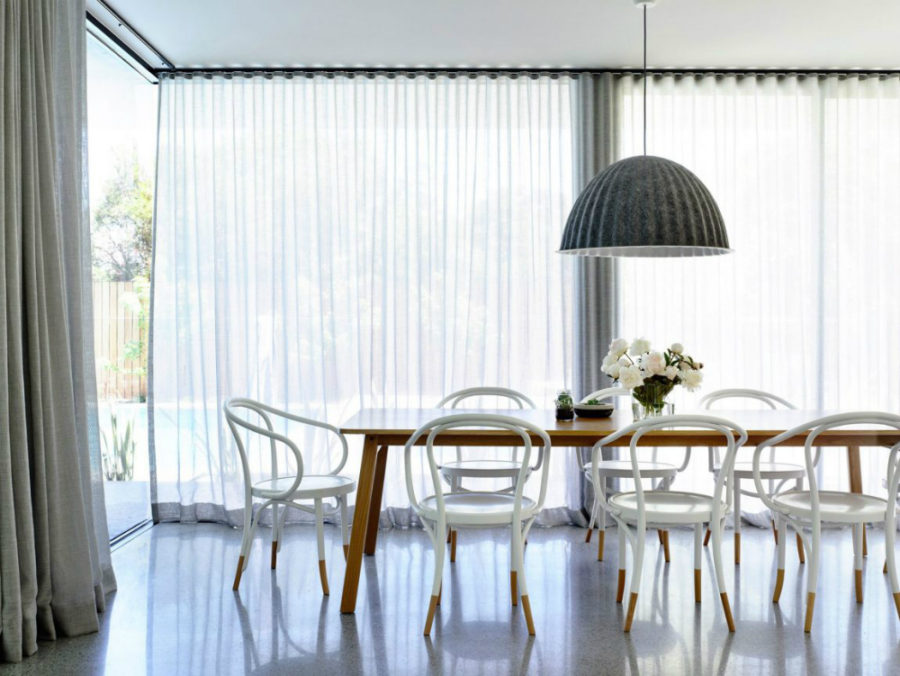 A light spacious dining area curtained from glazed walls