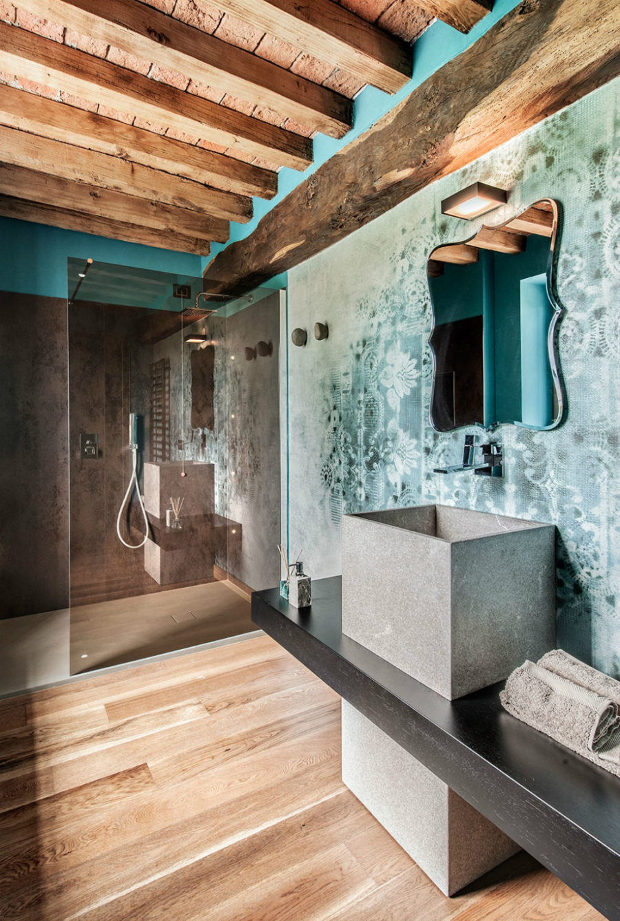 Fading lace patterns contrast with the worn wooden beams in the second bathroom
