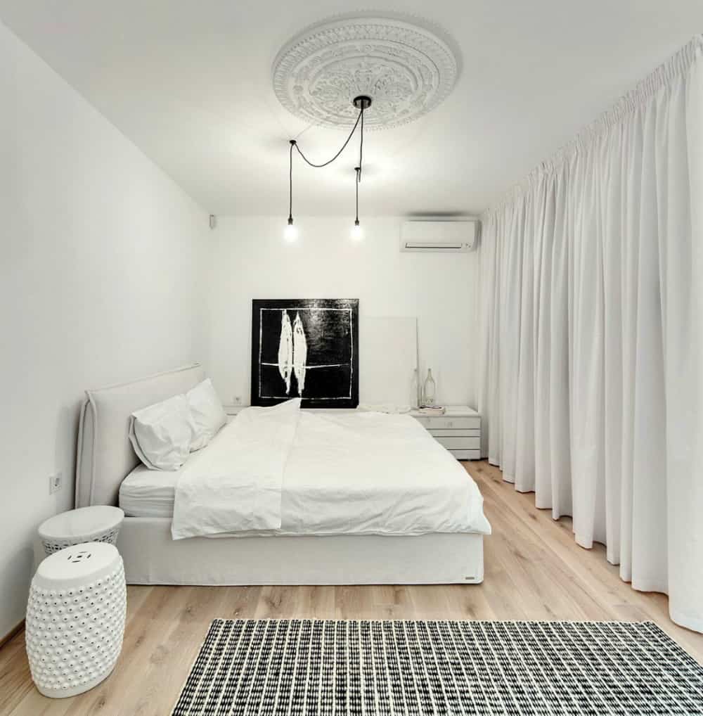 White bedroom with a soft bed and a ceiling medallion