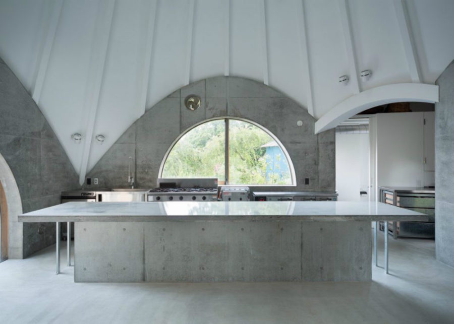 A big concrete kitchen island is a work space for one of the residents who's cook