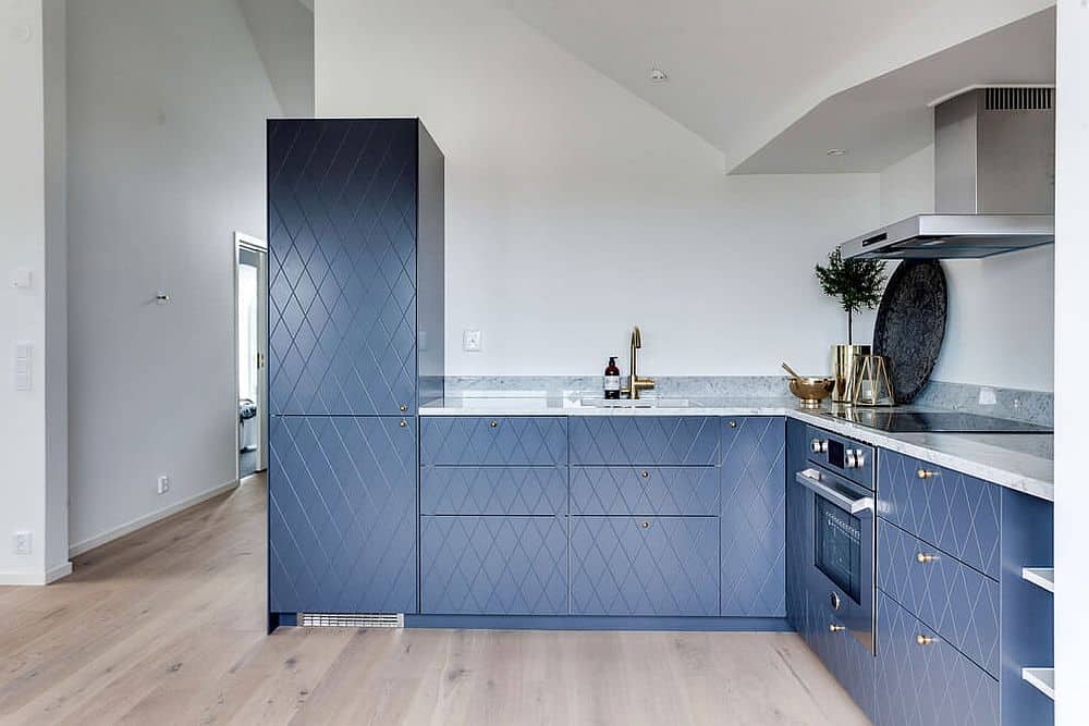 Blue kitchen cabinets make for a contrast in the white interior