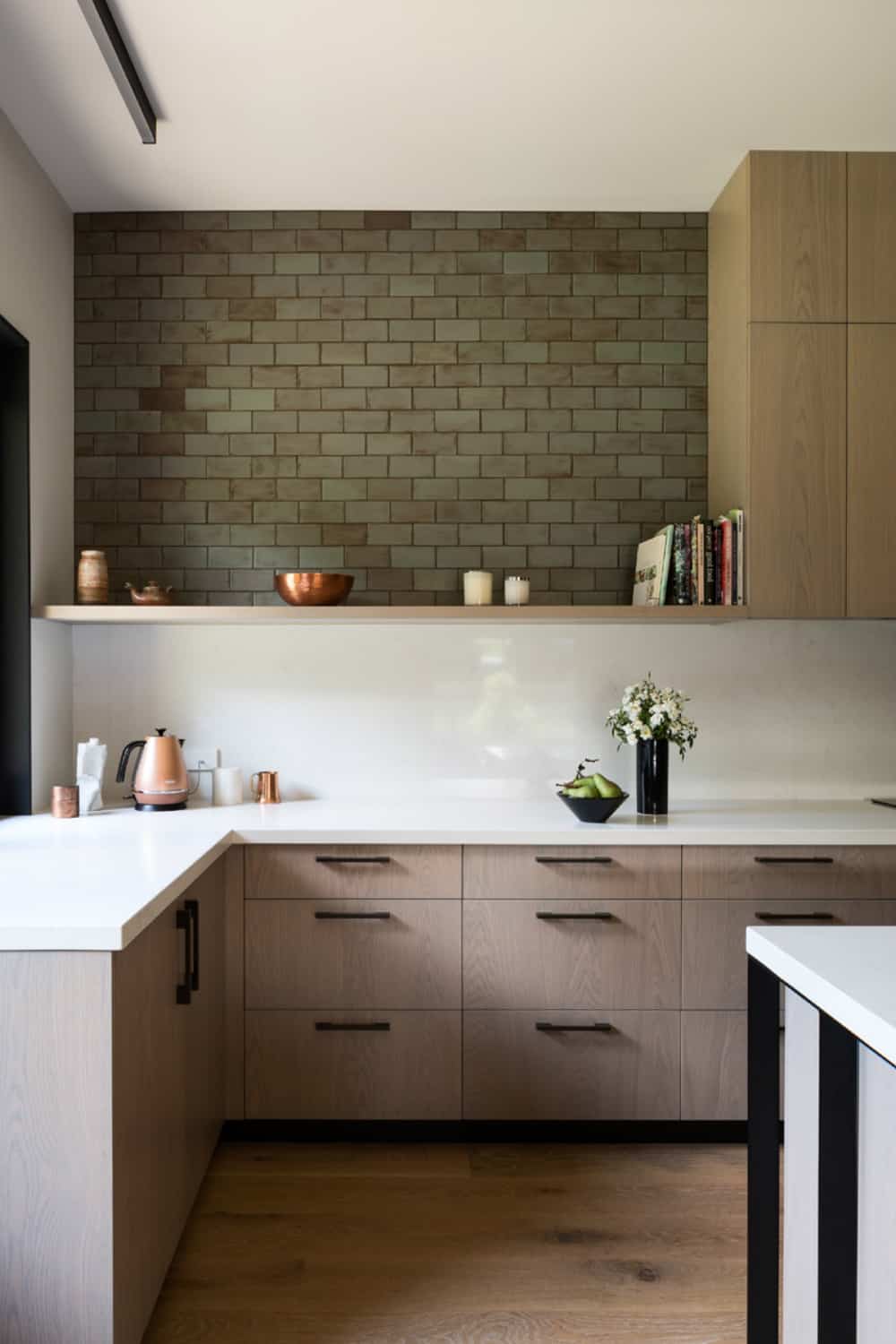Simple kitchen design involves Corian countertops and upper shelves