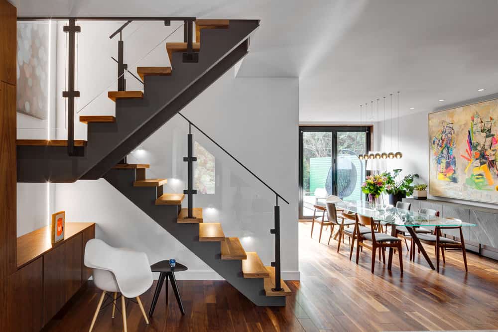 Wood and steel staircase features glass railing for an airier atmosphere