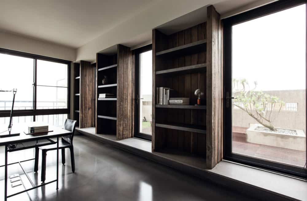 Built-in open shelving units in the home office interchange with huge windows