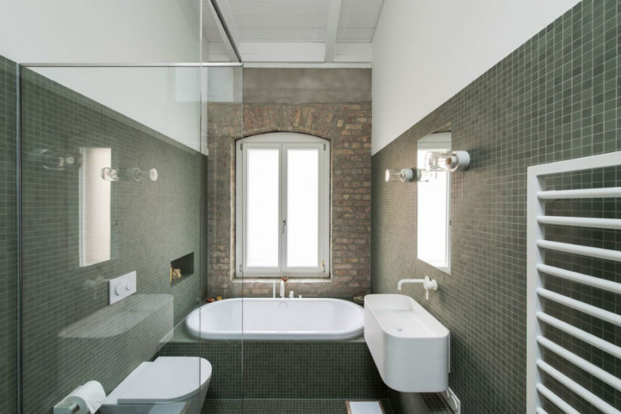 Even the green-tiled bath has a featured brick wall