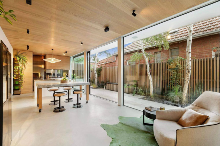 Kitchen and dining area visually shares space with the backyard thanks to sliding glass walls