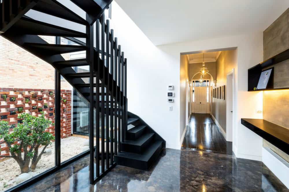 An architectural staircase makes a designing element in the hallway