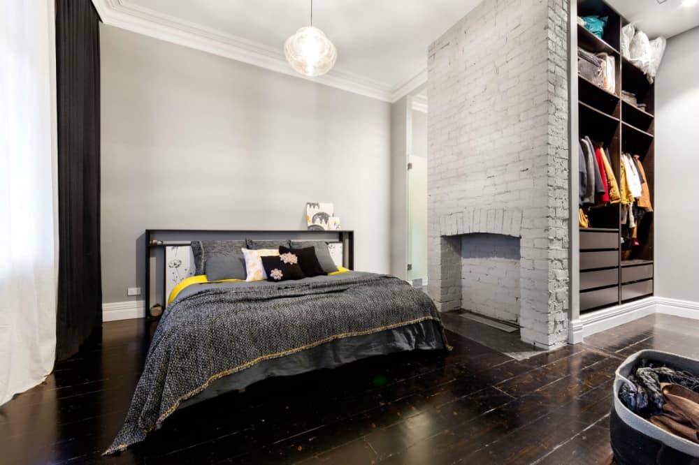Bedroom features its own closet and a fireplace mantel