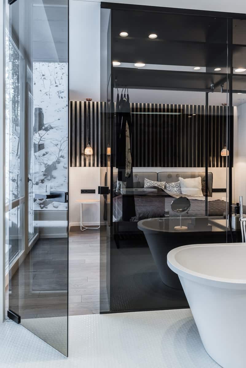 A glass partition between bath and bedroom is the best part of the design