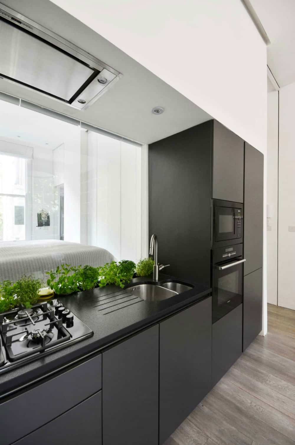 Kitchen backsplash is a transparent glass window into the bedroom