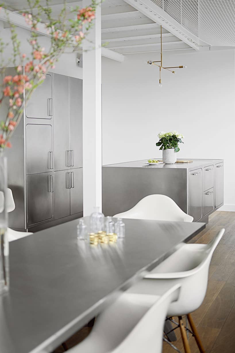 White chairs connects the dining area to both kitchen and the rest of the space