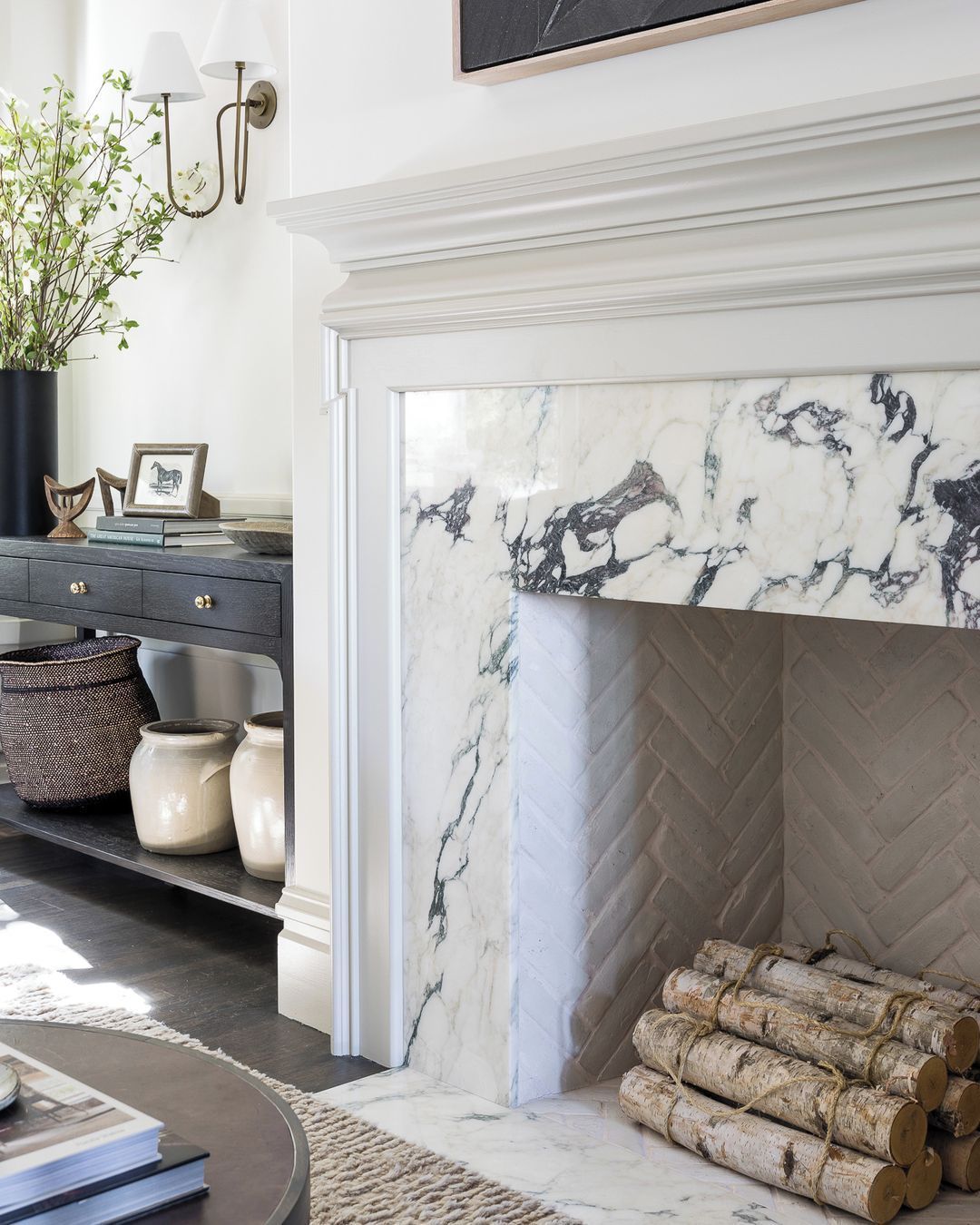 01-fireplace-tile-ideas-veined-marble-surround-brass-sconces