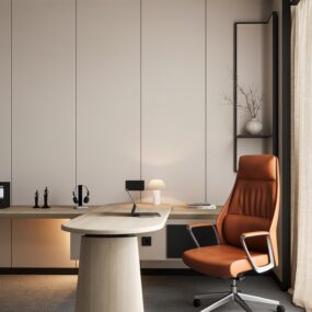 A minimalist home office with beige paneled walls, a light wood pedestal desk, orange leather high-back executive chair, laptop, small table lamp, and a vase of dried branches on a floating shelf.