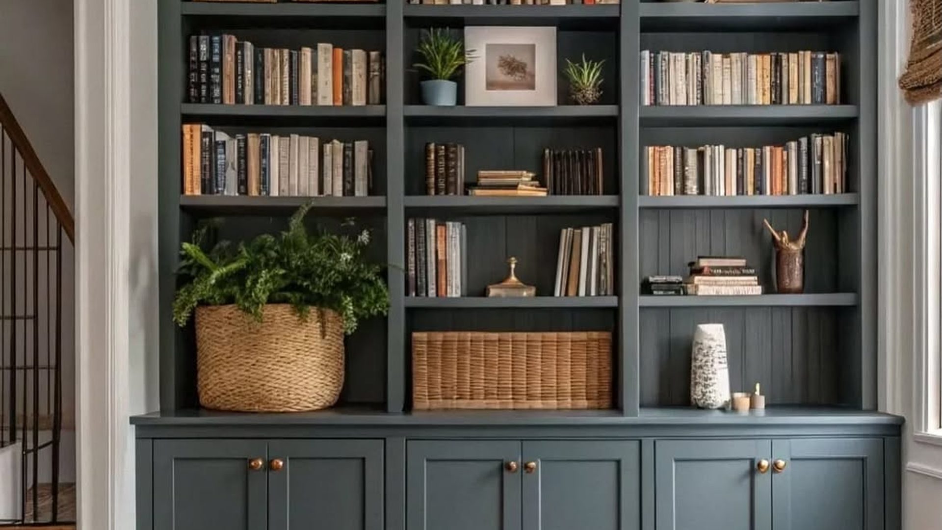 dark-teal-built-in-bookshelf-shaker-cabinets-woven-baskets-fern-plant