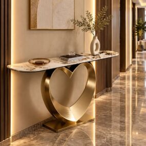 A luxury hallway console table with a gold heart-shaped base and veined marble top, styled with a donut vase of greenery and gold abstract art above.