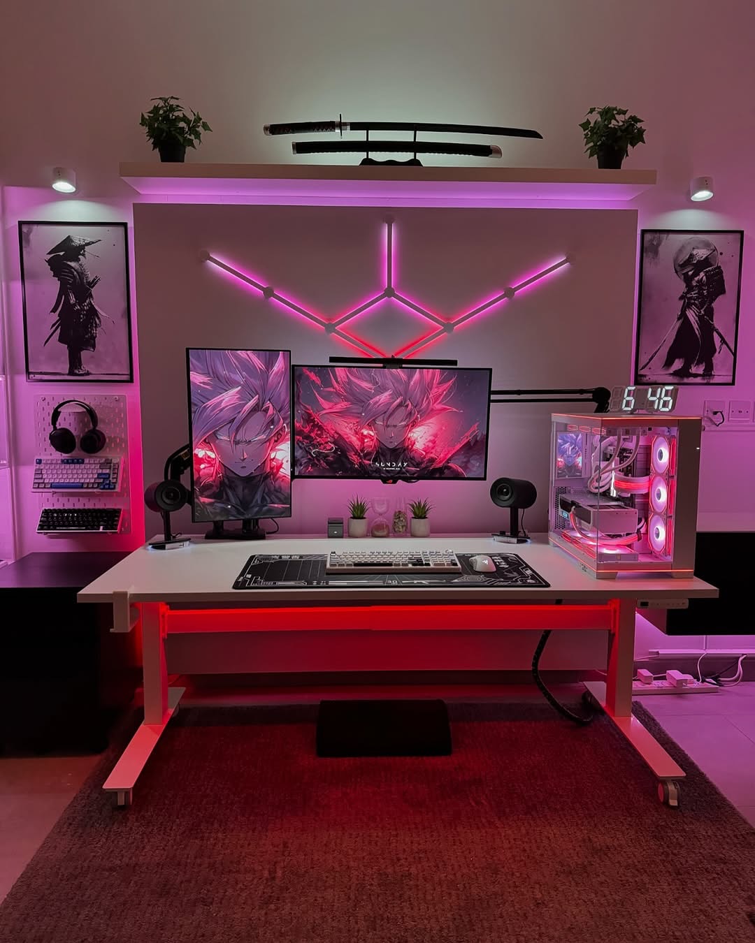 An anime-themed gaming setup with dual monitors, white keyboard, custom RGB pink lighting, clear PC tower, samurai posters, mounted katana shelf, headphones, and a mechanical keyboard on pegboard.