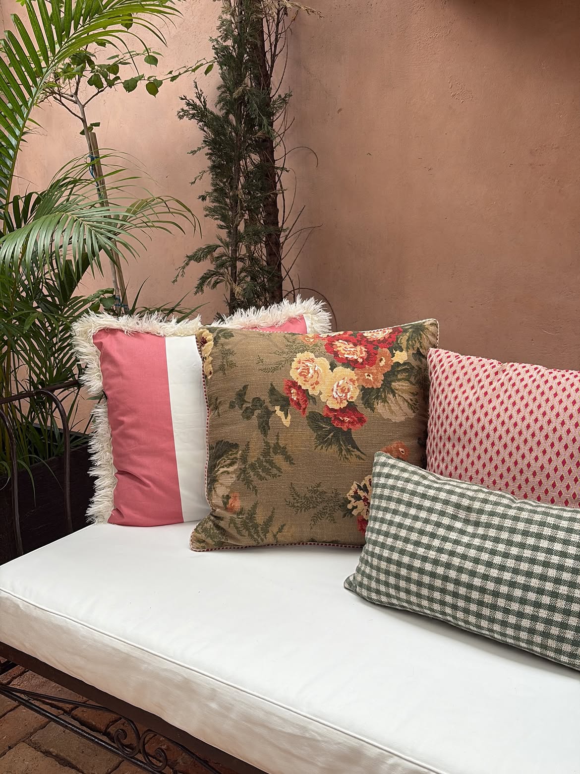 vintage-floral-pink-colorblock-green-gingham-cushions-iron-bench-terracotta-wall