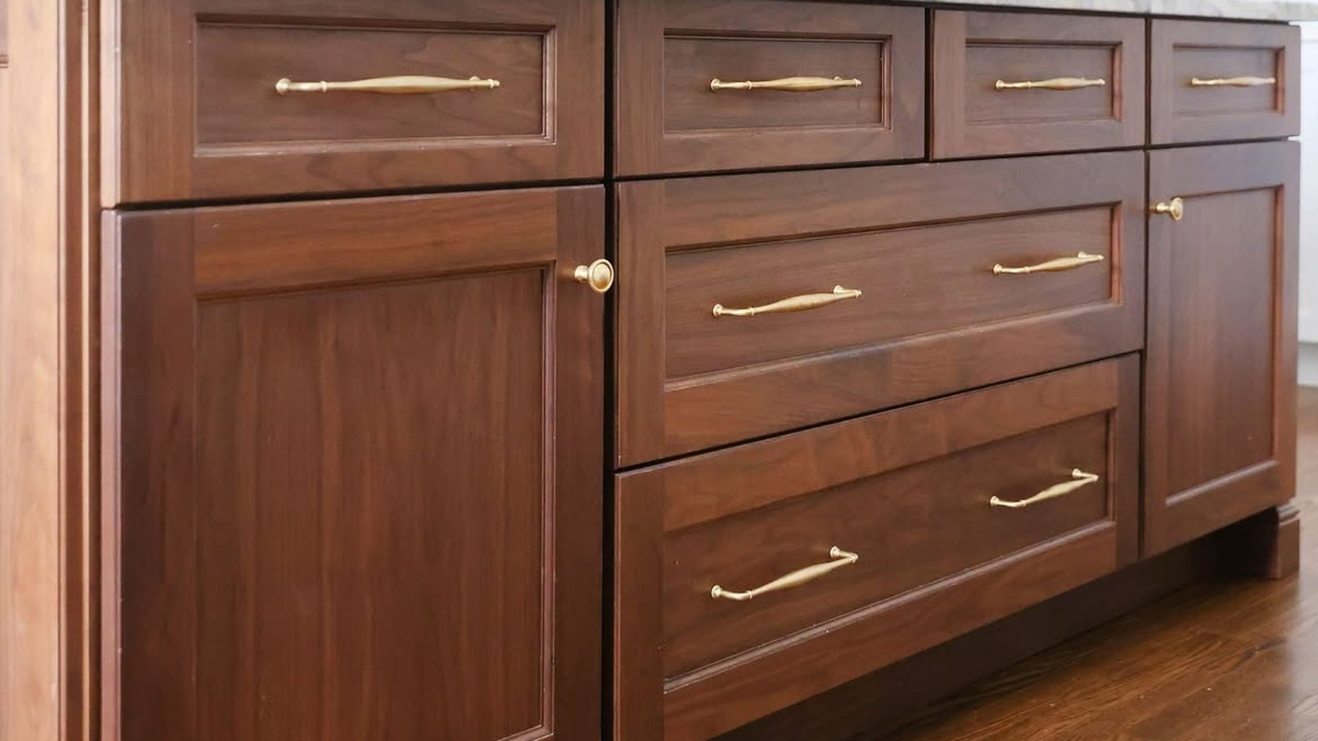 walnut-stained-kitchen-island-brass-bar-pulls-marble-top