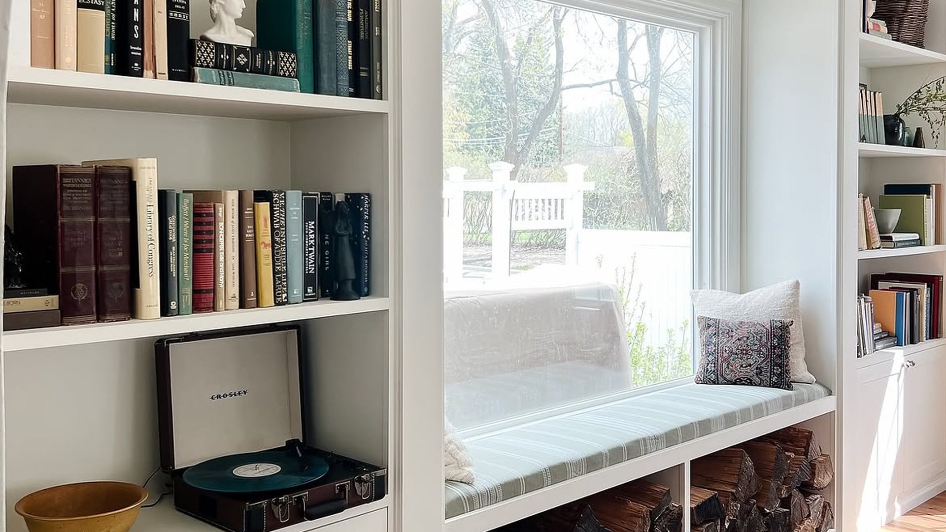 white-built-in-window-seat-firewood-storage-striped-cushion-record-player