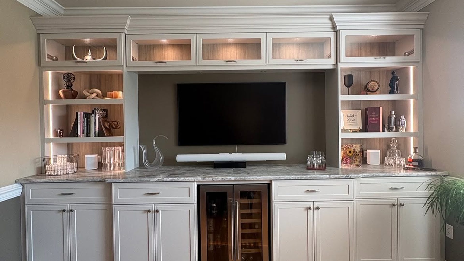 white-entertainment-built-in-wine-fridge-marble-counter-glass-cabinets-tv