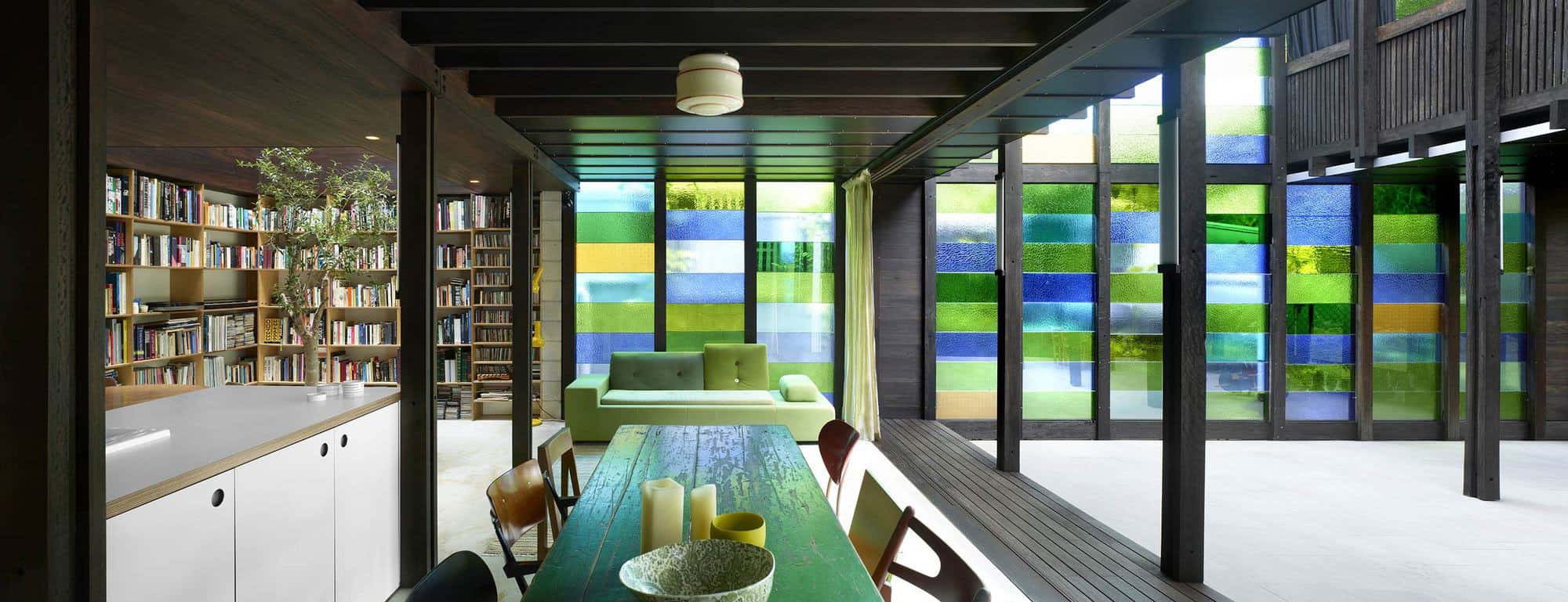 Cottage with Colored Glass Walls and Pre-existing Trees