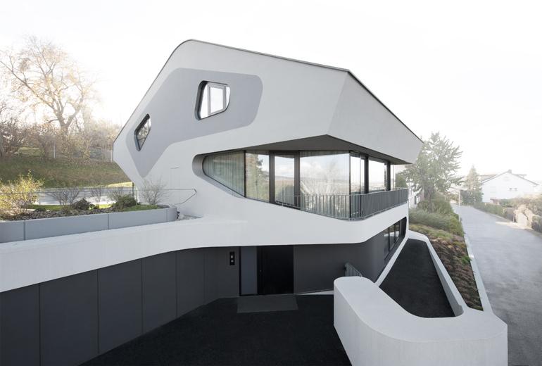 angular modern home features large curvaceous stairwell inside 2 street