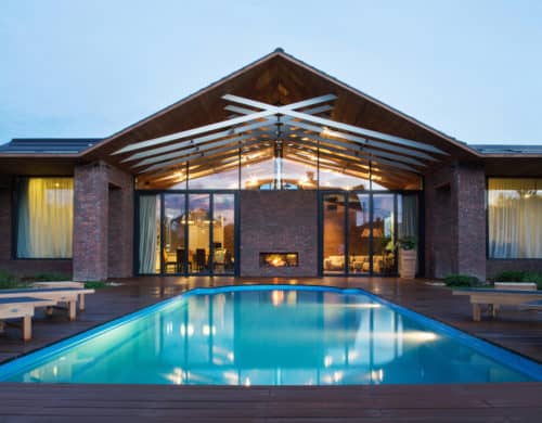 Exposed Trusses Create Artistic Composition within Brick Country Home