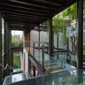 Outdoor Elevated Glass Walkway Connects Two Sections of House