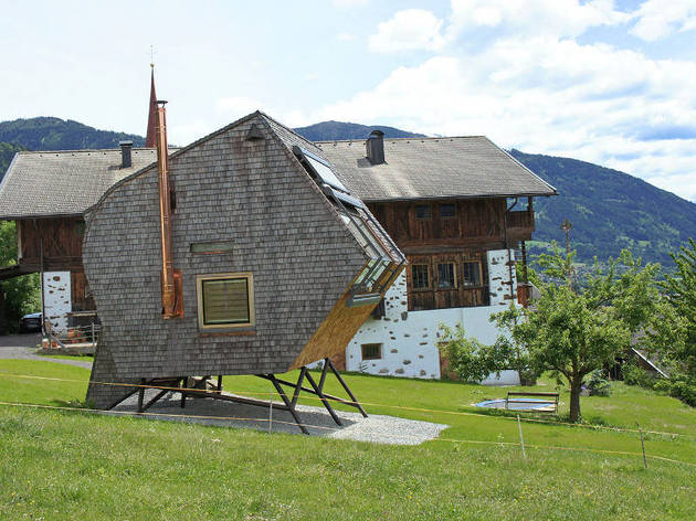 compact-irregularly-shaped-austrian-mountain-house-on-stilts-3-side-chimney.jpg