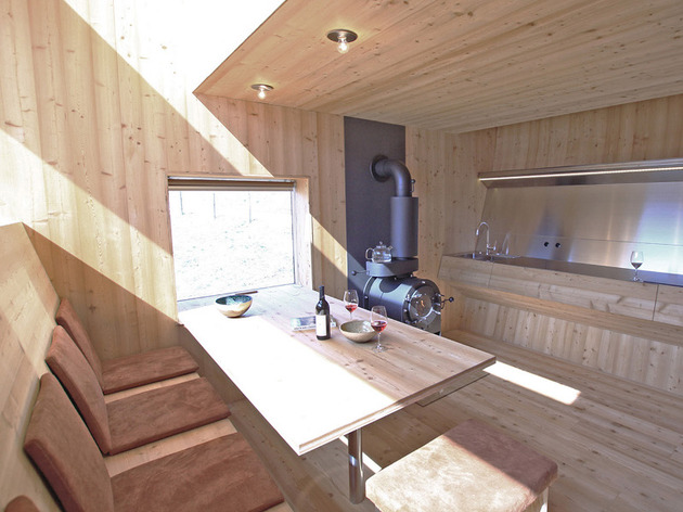 compact-irregularly-shaped-austrian-mountain-house-on-stilts-9-table-stove.jpeg