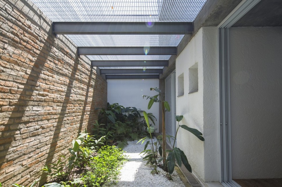 brazilian-concrete-house-built-around-three-story-courtyard-tree-10-side-garden.jpg