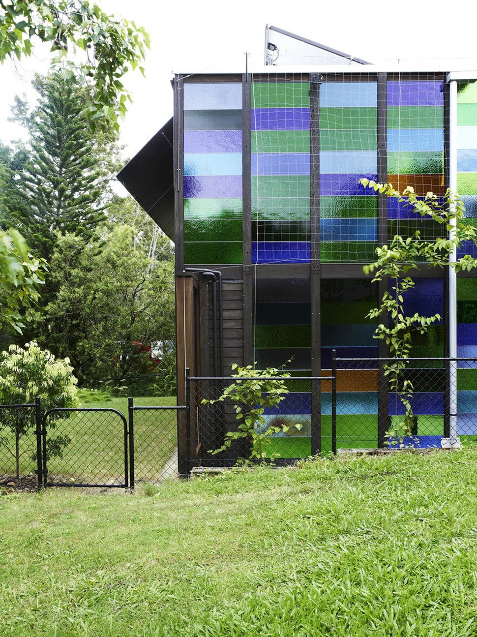 coloured-glass-walls-sparkle-from-cottage-addition-12-sideyard.jpg