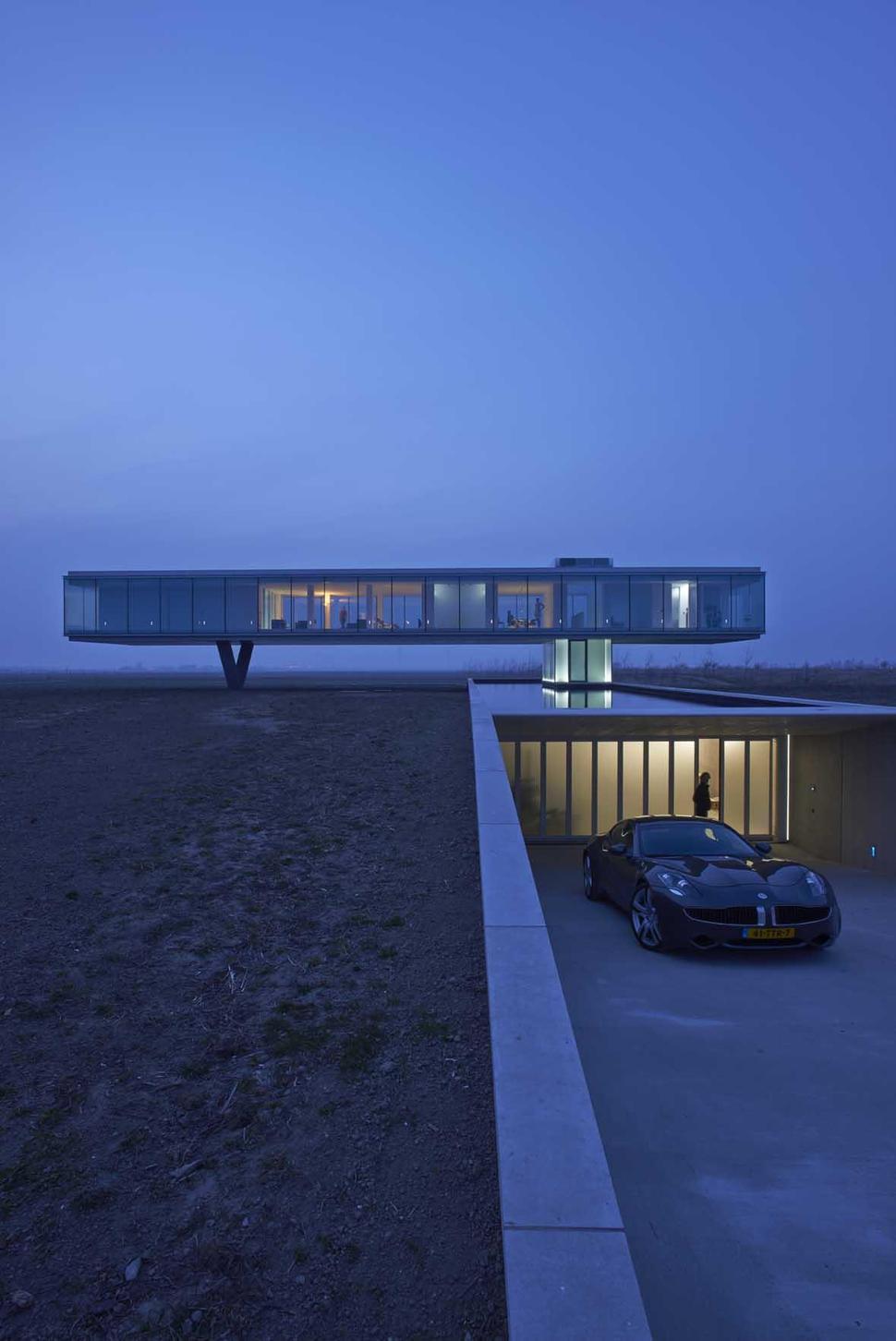 striking-minimal-glass-house-elevated-above-barren-landscape-4-far-night.jpg