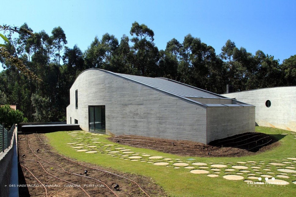 two-wing-portuguese-house-with-concrete-look-wood-exterior-6-sloping-profile.jpg