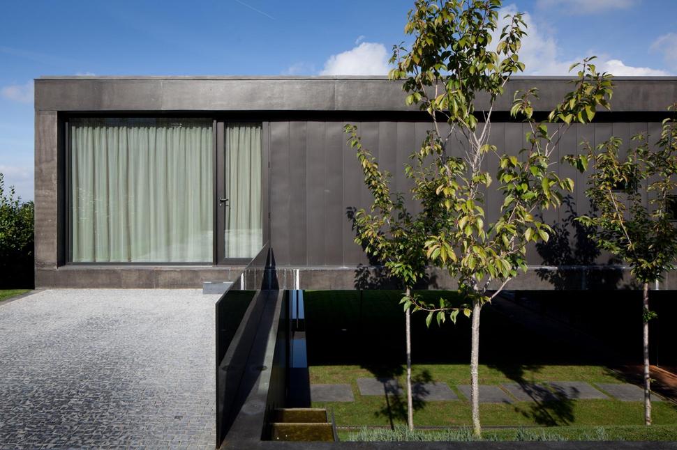 black-home-with-bright-interior-built-into-grassy-hillside-13-second-floor-deck-door.jpg