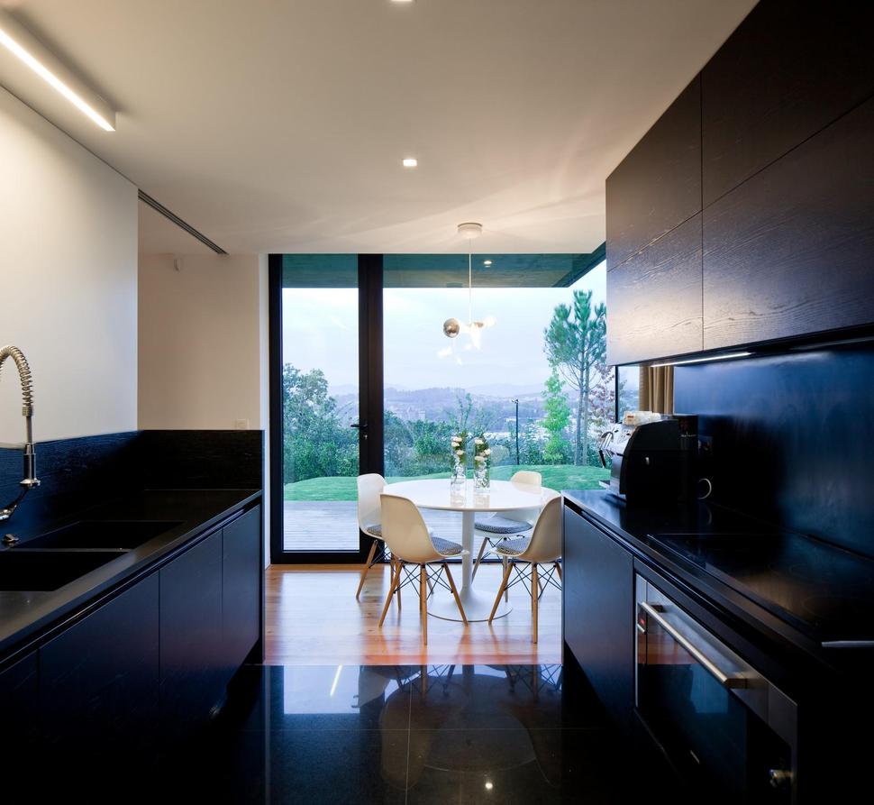 black-home-with-bright-interior-built-into-grassy-hillside-18-kitchen.jpg