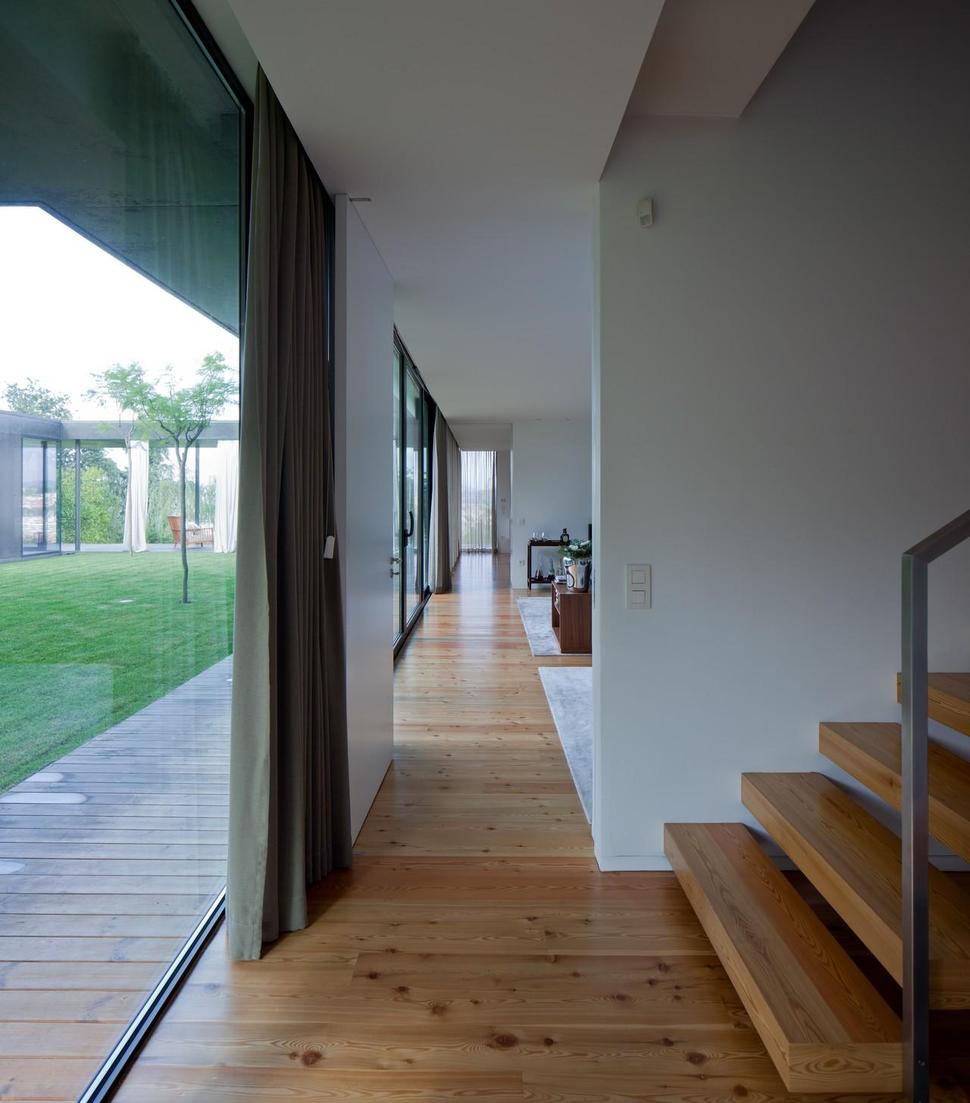 black-home-with-bright-interior-built-into-grassy-hillside-21-bottom-open-hallway.jpg