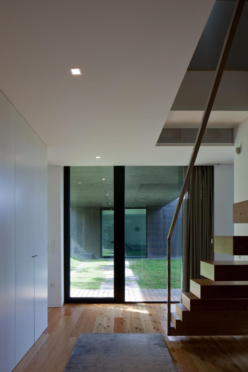 black-home-with-bright-interior-built-into-grassy-hillside-22-floating-stairs.jpg