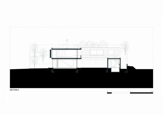 black-home-with-bright-interior-built-into-grassy-hillside-34-rear-facade.jpg