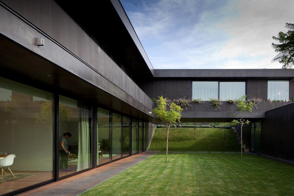 black-home-with-bright-interior-built-into-grassy-hillside-6-courtyard.jpg