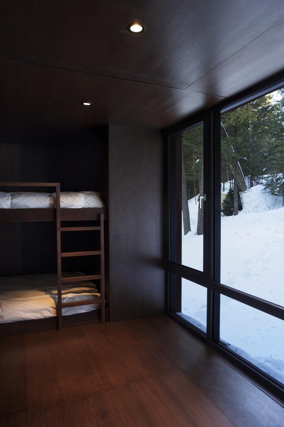 forest-getaway-cabin-dominated-by-warm-wood-boards-10-dark-bedroom.jpg